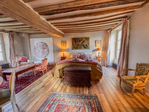 une chambre avec un lit, une table et des chaises dans l'établissement Manoir XV et Grange avec Piscine chauffée privée, à Saint-ouen-de-la-Cour