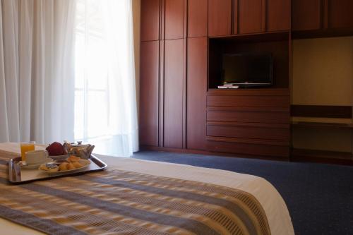 a hotel room with a tray of food on a bed at The Mayflower Hotel in Beirut