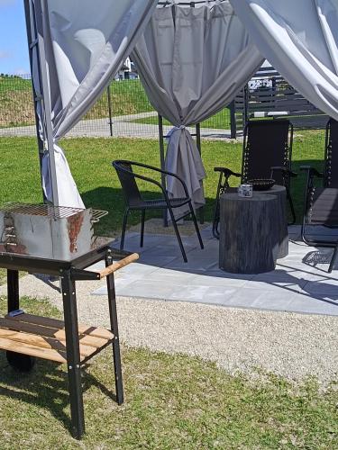 a tent with a table and chairs on the grass at Domek Pod Prehybą -Agroturystyka in Gaboń