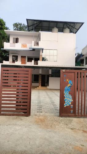 a building with a gate with a painting on it at Aswathy Bhavan in Vadakkāncheri