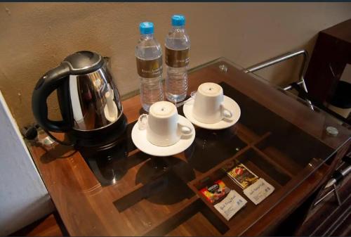 a coffee table with two cups and two bottles of water at Hotel Holitel in Parit