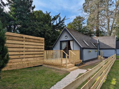 a backyard with a wooden fence and a house at Cear 2- Private Hot Tub- Perth-Pet Friendly Lodge in Almondbank