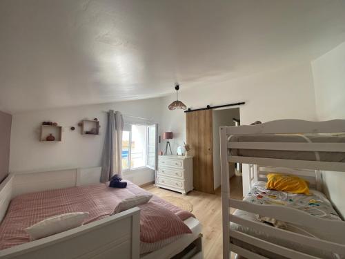 Un dormitorio con dos literas y una ventana. en Maison Mer Louis, en Saint-Pierre-dʼOléron