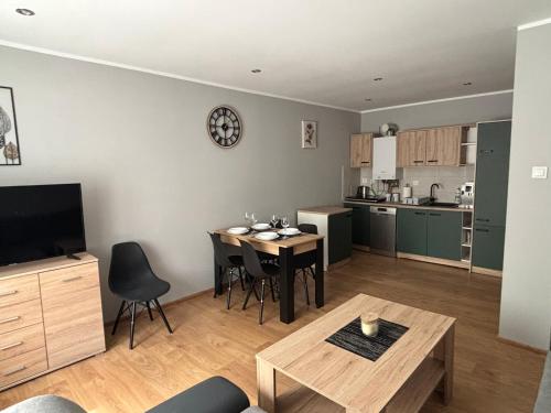 a living room with a table and a kitchen at Apartament u Wojtusia in Stronie Śląskie
