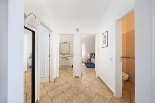 a hallway with a bathroom with a toilet and a sink at Casa Rapp in Alvor