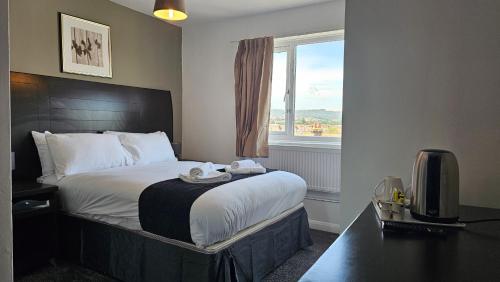 a hotel room with a bed and a window at The Strand Hotel in Eastbourne