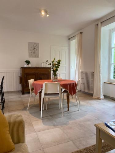une salle à manger avec une table et des chaises dans une pièce dans l'établissement Clos des Chardons - Le Jardin, à Saint-Aignan