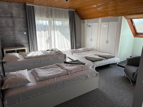 a room with three beds and a window at Bistro Apartman in Balatonboglár