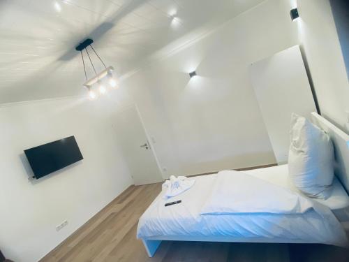 a white room with a bed and a tv at Rhein-Neckar-Apartments Viernheim in Viernheim
