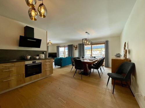 une cuisine et une salle à manger avec une table et des chaises dans l'établissement Homency - Residence Parenthèse A14, à L'Alpe-d'Huez