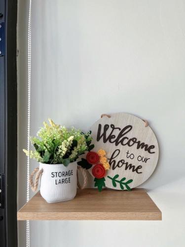 a welcome to our home sign and a plant on a shelf at Minh Anh Villa & Apartment in Thôn Trường Giang
