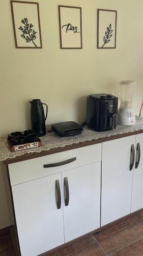a kitchen counter with a coffee maker and a microwave at Recanto da Nicea in Córrego do Bom Jesus