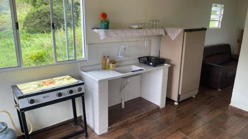 eine kleine Küche mit Spüle und Herd in der Unterkunft Recanto da Nicea in Córrego do Bom Jesus