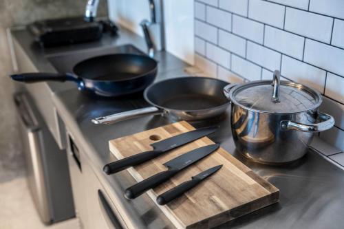 a kitchen stove with a cutting board and two pots and pans at Taketo Stay Kotoni 101 in Sapporo
