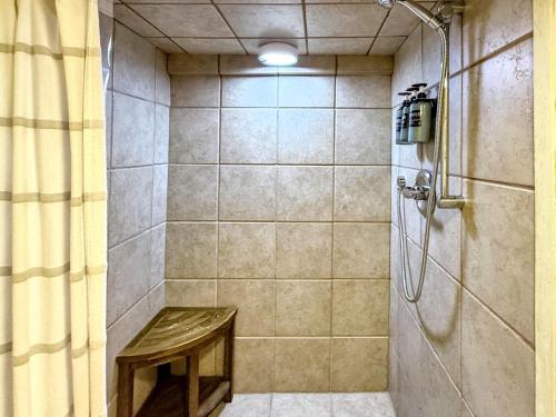 a bathroom with a shower with a bench in it at 1930's Highlands Hideaway in Highlands