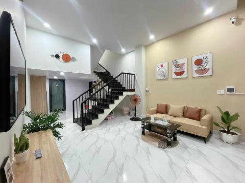 a living room with a couch and a staircase at Minh Anh Villa & Apartment in Thôn Trường Giang
