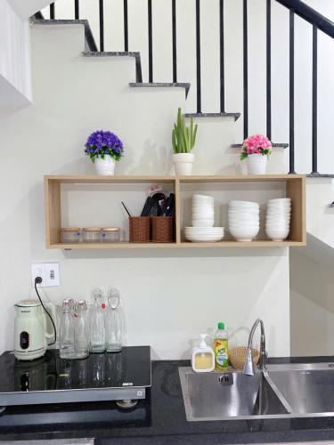 a kitchen with a sink and a shelf with dishes at Minh Anh Villa & Apartment in Thôn Trường Giang