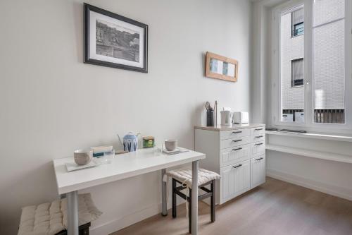 une cuisine blanche avec un bureau et une fenêtre dans l'établissement Appartement cosy pour 2, sur Nantes, à Nantes