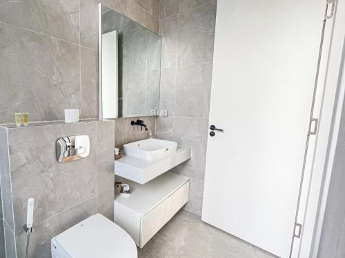 a bathroom with a sink and a toilet and a mirror at Villa Luxury Anna Airport in Cam Lâm