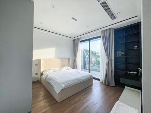 a bedroom with a bed and a large window at Villa Luxury Anna Airport in Cam Lâm