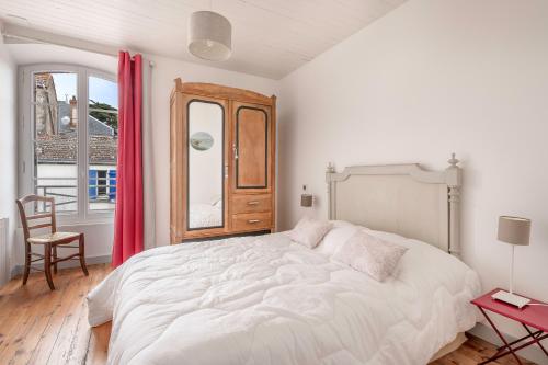 a white bedroom with a large bed and a window at Villa pour 7 adultes, 1 enfant, a 400m de la mer in Préfailles
