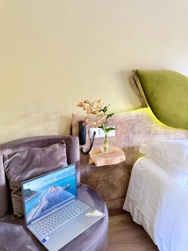 a laptop computer sitting on a chair in a bedroom at Beleza Serra Guide Hotel in Geres