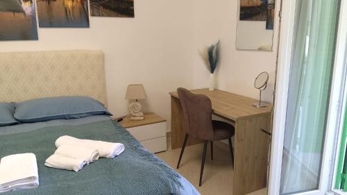 een slaapkamer met een bed en een bureau met een stoel bij Vello Blu in Giovinazzo