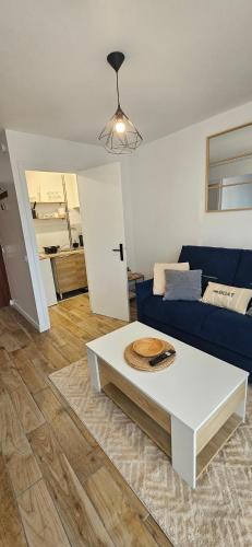 un salon avec un canapé bleu et une table dans l'établissement Studio Voltaire - Centre ville, à Saint-Brieuc