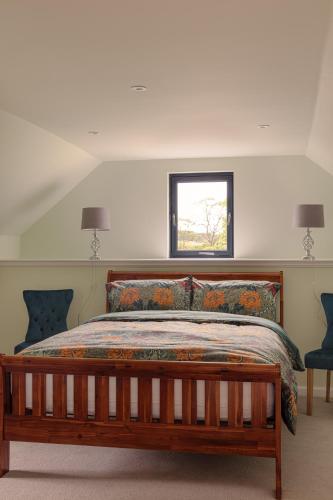 a bedroom with a wooden bed with a window at Elrick Estate - Coach House in Newmacher