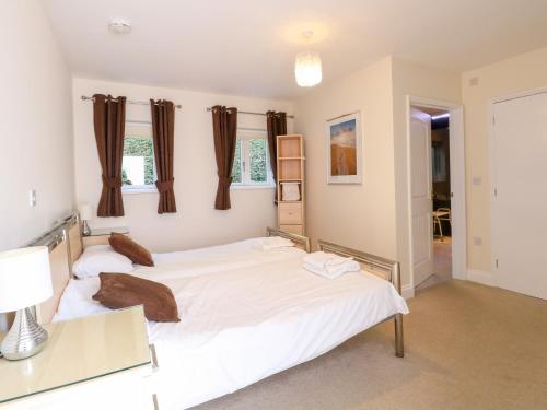 deux lits jumeaux dans une chambre avec fenêtres dans l'établissement Rookyard Cottage, à Halesworth