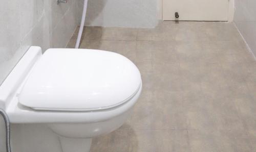 a bathroom with a white toilet in a room at Hotel Kamron Near Airport Road Sector 78 Mohali Chandigarh in Mohali