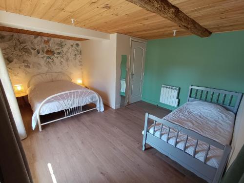 une chambre avec deux lits et un parquet dans l'établissement Gîte de la Forêt, à Le Mesnil-Rogues