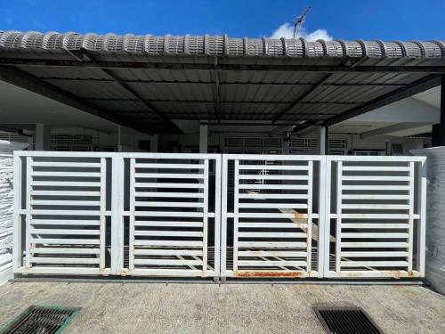 een witte poort voor een gebouw bij Qisa Guesthouse 03 in Arau