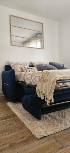 - un lit dans une chambre avec un miroir et un tapis dans l'établissement Studio Voltaire - Centre ville, à Saint-Brieuc