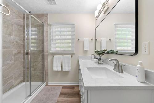 ein weißes Badezimmer mit Waschbecken und Dusche in der Unterkunft Cozy Cottage for 6 Pet Fenced in Marietta