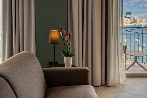 a living room with a chair and a vase of flowers at Waterfront in Sliema