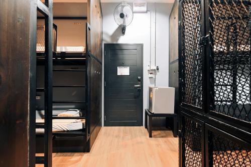 a room with black bunk beds and a room with a door at Castle Black Bangkok in Bangkok