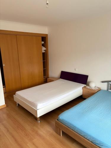 a bedroom with two beds and a cabinet at Villa Quinta Dom Reis in Batalha