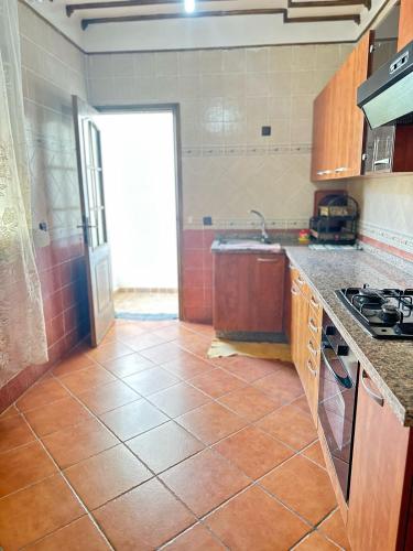 a kitchen with a tiled floor and a stove at Appartement Sidi Bouzid in El Jadida