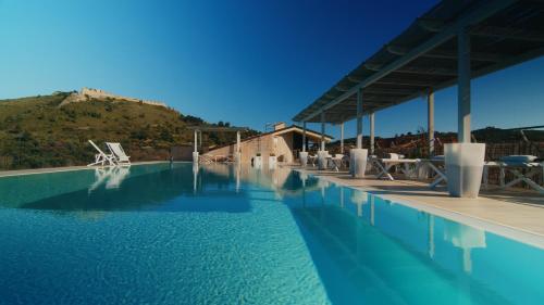 a large swimming pool with a mountain in the background at A Point Porto Ercole Resort & Spa in Porto Ercole