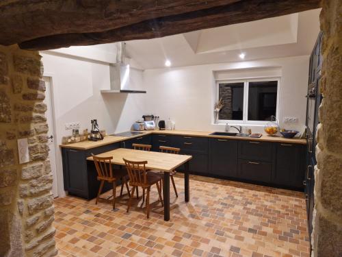 - une cuisine avec une table et des chaises en bois dans l'établissement Cottage du Golfe - 2 logements - 18 personnes, à Plescop