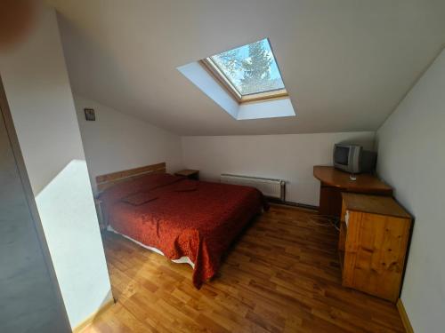 a bedroom with a bed and a skylight at Casa bunicilor dor de Bucovina in Câmpulung Moldovenesc