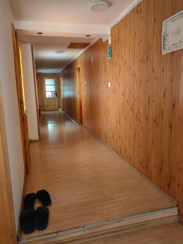 a hallway with wood paneling and black bowls on the floor at Casa bunicilor dor de Bucovina in Câmpulung Moldovenesc