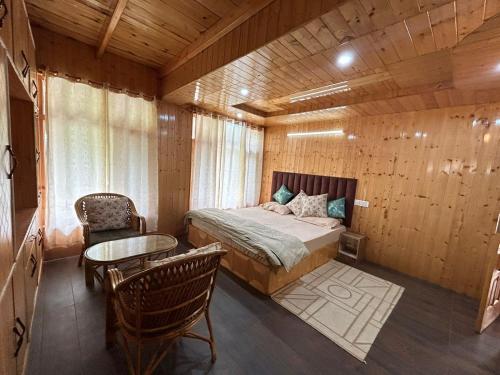 a bedroom with a bed and a table and chairs at Wander Vale in Haripūr