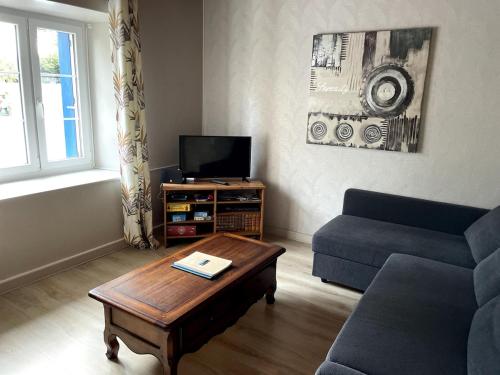 a living room with a couch and a coffee table at Maison à quelques mètres de la mer in Saint-Jean-du-Doigt