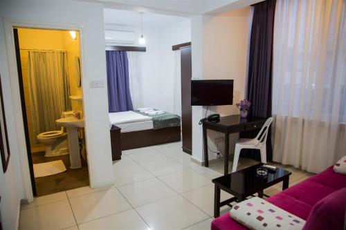 a living room with a couch and a room with a bedroom at Cyprus Apart Hotel in Mağusa