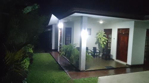 a house with a porch with a table and chairs at King Elephant, Homestay Pinnawala in Rambukkana