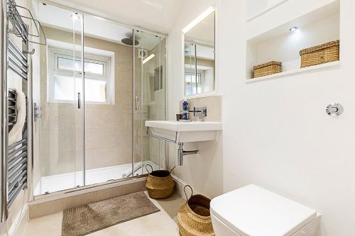 a bathroom with a shower and a sink and a toilet at Stylish Kings Cross Apartment with Garden in London