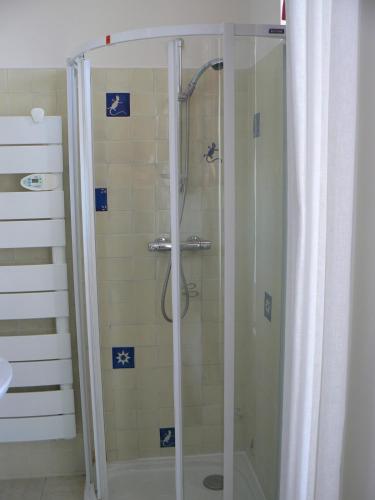 une douche avec une porte vitrée dans une salle de bain dans l'établissement KER MARY appartement lumineux 50 mètres de la plage, à Pornic