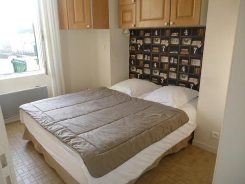 une chambre avec un grand lit dans une pièce dans l'établissement KER MARY appartement lumineux 50 mètres de la plage, à Pornic